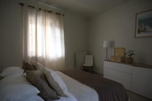 a bedroom with a bed with pillows and a window at Langhem Suites Luxury Apartments in Castiglione Falletto