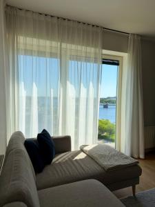 a living room with a couch and a large window at River Apartment in Pärnu
