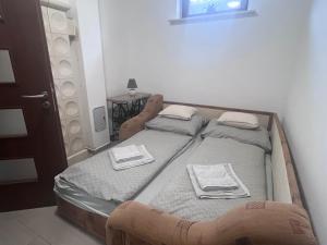 a bedroom with two beds with towels on them at Vadkörte Balaton Apartman in Balatonfůzfő