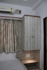 a bedroom with a bed with a wooden cabinet at Palash Baag in Jodhpur