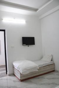 a bedroom with a bed and a flat screen tv on the wall at Palash Baag in Jodhpur