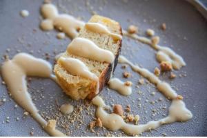 a piece of cake with icing on a plate with a knife at Entalet Mara Camp in Talek +30 photos