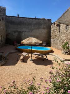 a picnic table with a surfboard and an umbrella at Le Son des Violons in Sallèles-dʼAude