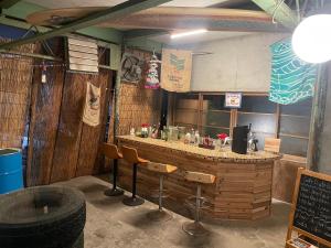 a restaurant with a bar with stools and a sign at Old Sunny Garage in Tosashimizu