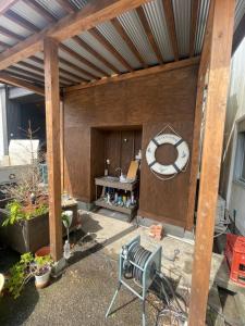 a patio with a large wooden structure with a bench at Old Sunny Garage in Tosashimizu +9 photos