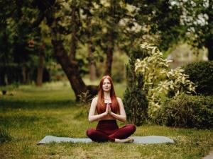 a woman sitting in the grass doing meditation at Ibis Budapest Citysouth in Budapest