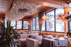 a dining room with tables and chairs and windows at Inn OZZ Almaty in Almaty