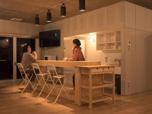 two people standing in a kitchen with a counter at cocomio in Bungoono