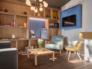 ein Wohnzimmer mit Sofa, Tisch und Stühlen in der Unterkunft ibis Chur in Chur