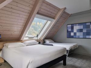 zwei Betten in einem Zimmer mit großem Fenster in der Unterkunft ibis Chur in Chur