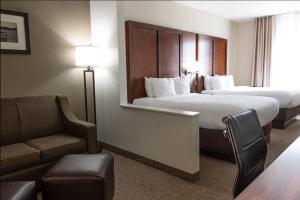 a hotel room with two beds and a chair and a couch at Rapid River Lodge in Baxter +21 photos
