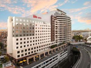 a big white building with a train in front of it at ibis Sydney Darling Harbour in Sydney