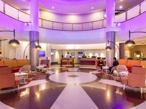 people sitting in a lobby with purple lighting at Novotel Perth Langley in Perth
