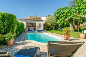 a swimming pool with two chairs and a house at Mon Cabanon Roquemaure in Roquemaure