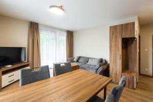 a living room with a table and a couch at TATRYSTAY Happy Nest Apartments in Tatranská Lomnica