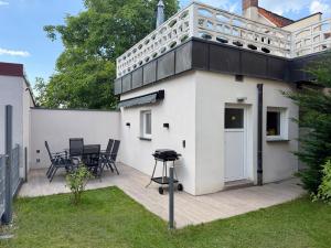 a white house with a patio and a table at Ferienwohnung mit Garten und Parkplatz mitten in Neumarkt in Neumarkt in der Oberpfalz