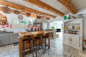 a kitchen with white cabinets and bar stools at Mon Cabanon Roquemaure in Roquemaure
