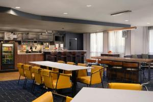 a restaurant with tables and chairs and a bar at Courtyard by Marriott Valdosta in Valdosta
