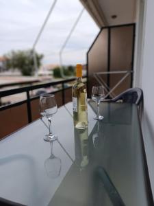a bottle of wine and two wine glasses on a table at Ioannis Fotinos Studios in Lygia +4 photos