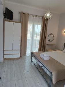 a bedroom with a bed and a tv and a dresser at Ioannis Fotinos Studios in Lygia