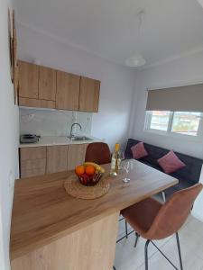 a kitchen with a table with a bowl of fruit on it at Ioannis Fotinos Studios in Lygia