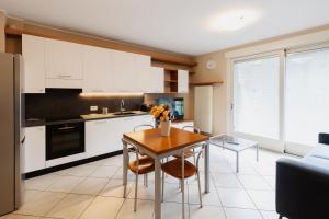 a kitchen with a table and chairs and a kitchen with white cabinets at Residenza CONCORDIA in Sondrio