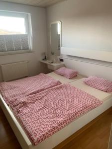 a bedroom with two beds with pink sheets and a mirror at Wappensaal Dhaun in Hochstetten-Dhaun