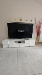 a flat screen tv sitting on top of a white entertainment center at Sole del Garda Haus in Desenzano del Garda