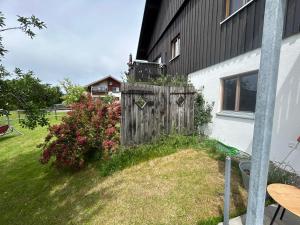 a backyard with a wooden fence next to a house at Beim Baltas in Wildpoldsried