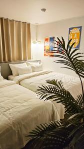 a bedroom with two beds and a plant at Hotel Amy in Pup'yŏng-yŏk