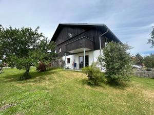 a black and white barn with a grass yard at Beim Baltas in Wildpoldsried