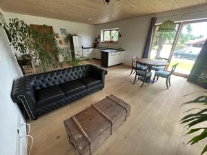 a living room with a black leather couch and a table at Beim Baltas in Wildpoldsried