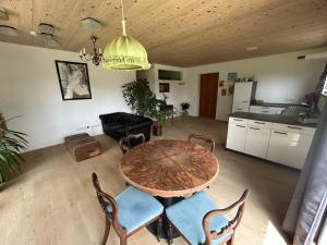 a living room with a wooden table and chairs at Beim Baltas in Wildpoldsried