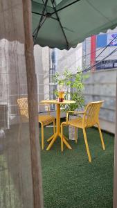 a table and chairs under an umbrella on a patio at Hotel Amy in Pup'yŏng-yŏk