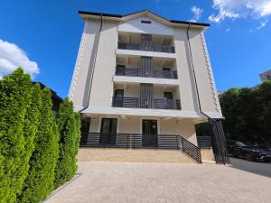 a tall white building with a balcony at Jolie Boutique Hotel in Craiova