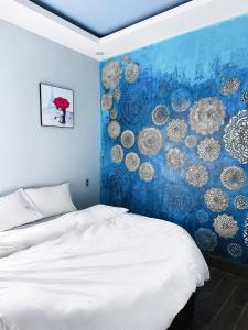 a bedroom with a bed with a blue wall at Victoria Hostel Huế in Hue