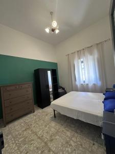a bedroom with a white bed and a dresser at Vico Poerio 1 in Tursi