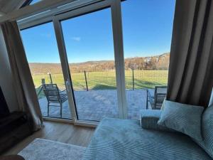 a living room with a couch and a sliding glass door at Fernblick- Sauna- WLAN- Haus 2 in Neheim-Hüsten