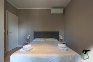 a bedroom with a large white bed with towels on it at Hotiday Padova San Giuseppe in Padova