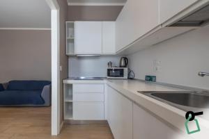 a white kitchen with a sink and a microwave at Hotiday Padova San Giuseppe in Padova