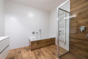 a bathroom with a tub and a shower stall at TATRYSTAY Happy Nest Apartments in Tatranská Lomnica +20 photos