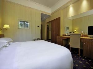a hotel room with a bed and a desk with a computer at Mercure Reggio Emilia Centro Astoria in Reggio Emilia