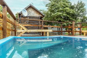 a large swimming pool with a wooden house at CASA HAIDUCILOR Green Codru in Codru
