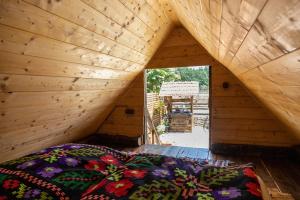 a room with a bed in a wooden house at CASA HAIDUCILOR Green Codru in Codru