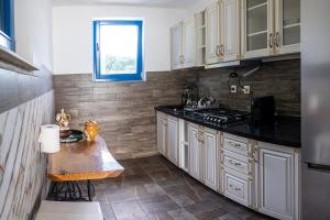 a kitchen with white cabinets and a counter top at CASA HAIDUCILOR Green Codru in Codru