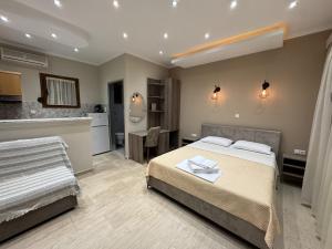 a bedroom with a large bed and a kitchen at Kapsogeorgis Rooms in Koinyra