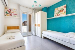 two beds in a room with blue walls at B&B Acquamarina in Gallipoli