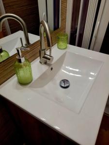 ein weißes Waschbecken mit zwei Wasserhähnen in einem Badezimmer in der Unterkunft Rustic ABAT 18 in Puigcerdà