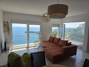 a living room with a couch and large windows at Apartman Magdalena in Budva