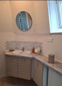 a bathroom with a sink and a mirror on the wall at Grand gîte 150 m2 - 4 chambres - Salle de jeux avec billard et fléchettes in Péronne +13 photos